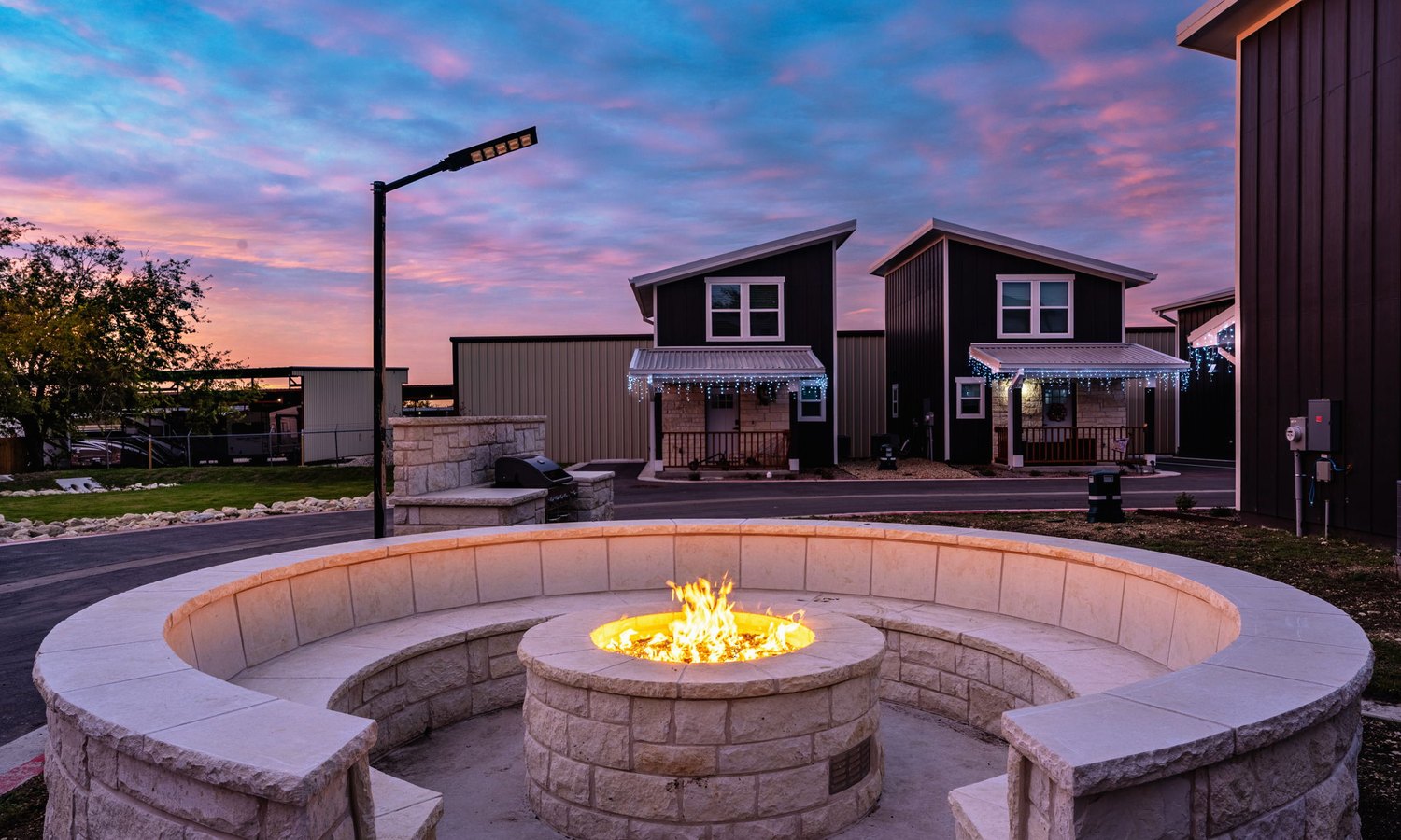 Limestone fire pit lit at dusk with circular seating