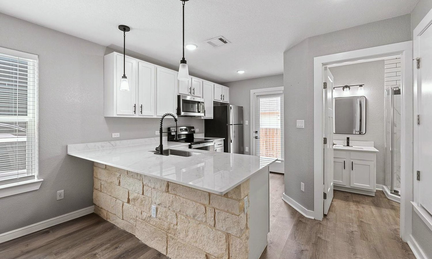 Kitchen with a stone faced island and white quartz worktop