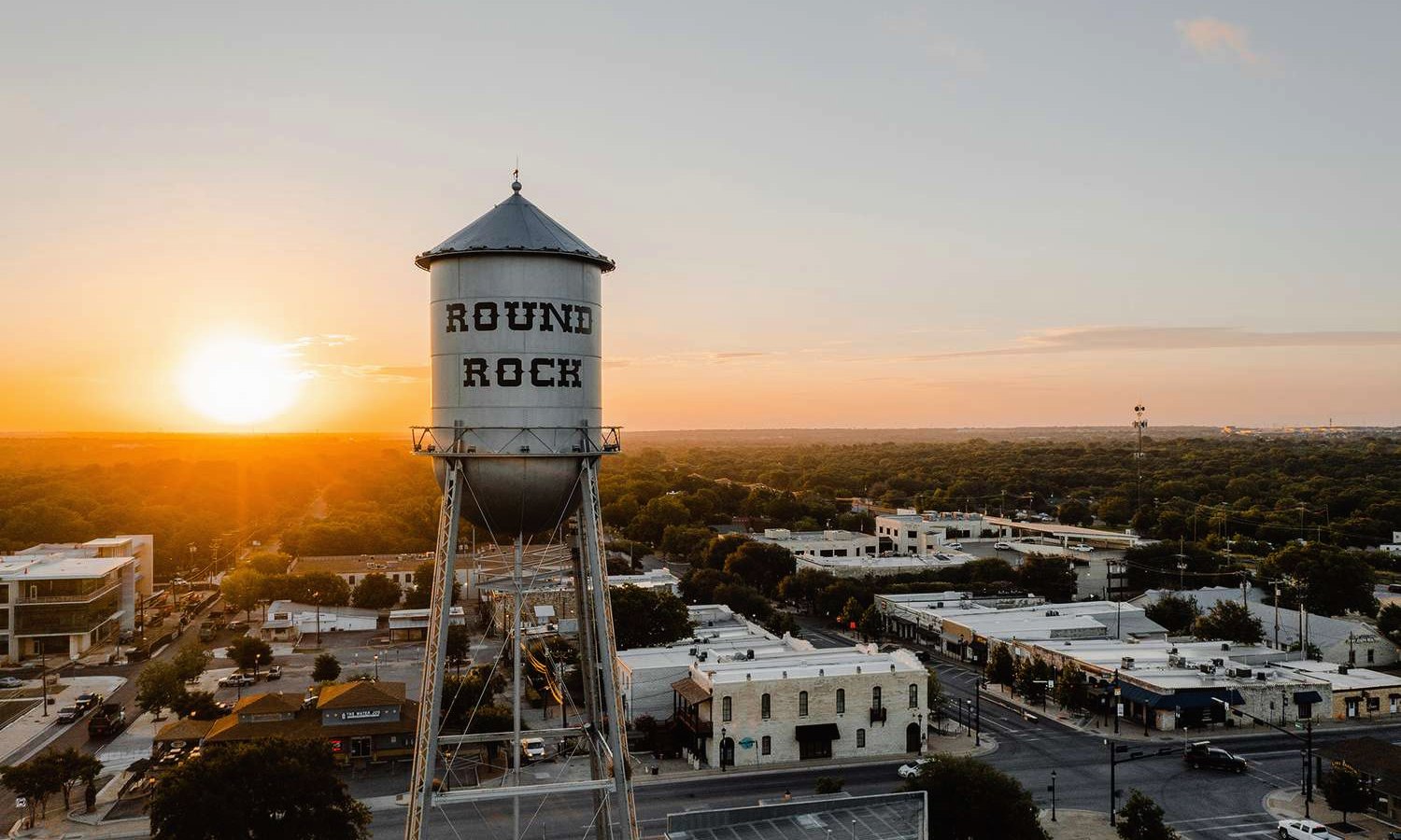The historic Round Rock water tower above downtown at sunset