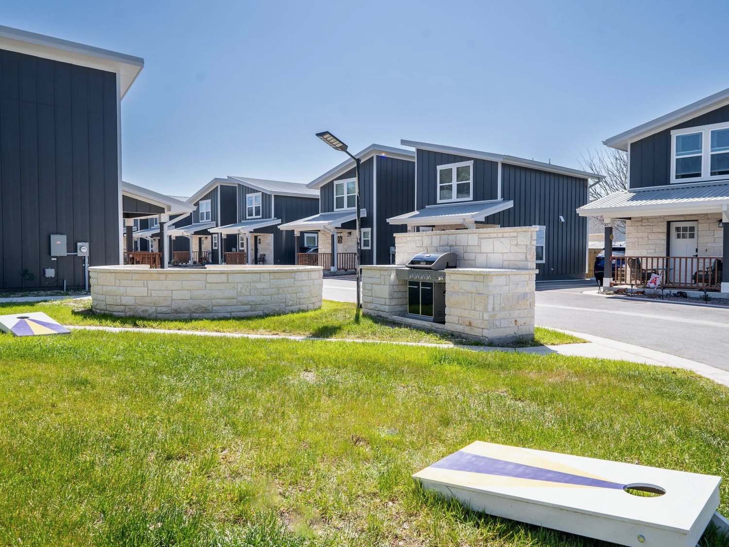 Shared stone fire pit, grill and green space at the centre of the community