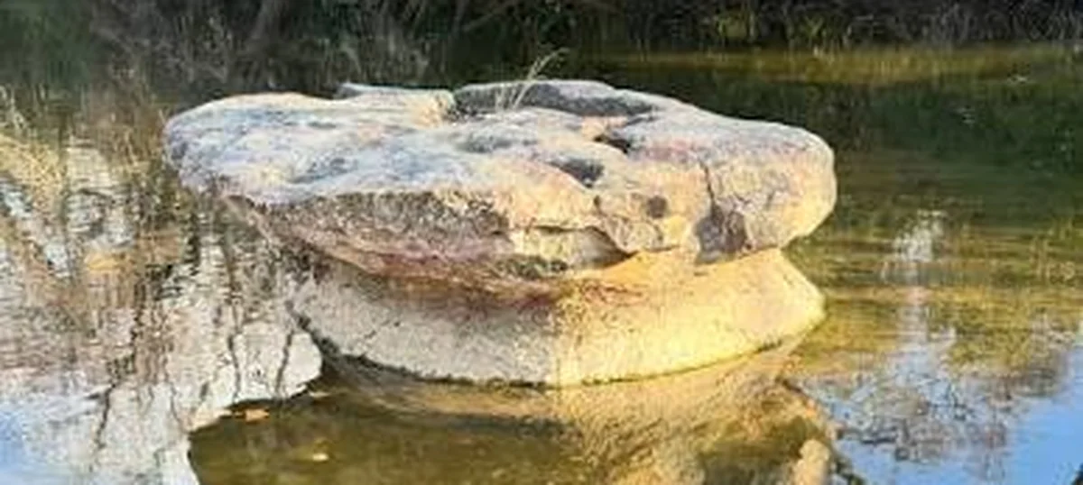 The round rock, a table-shaped limestone slab in Brushy Creek, Round Rock, Texas