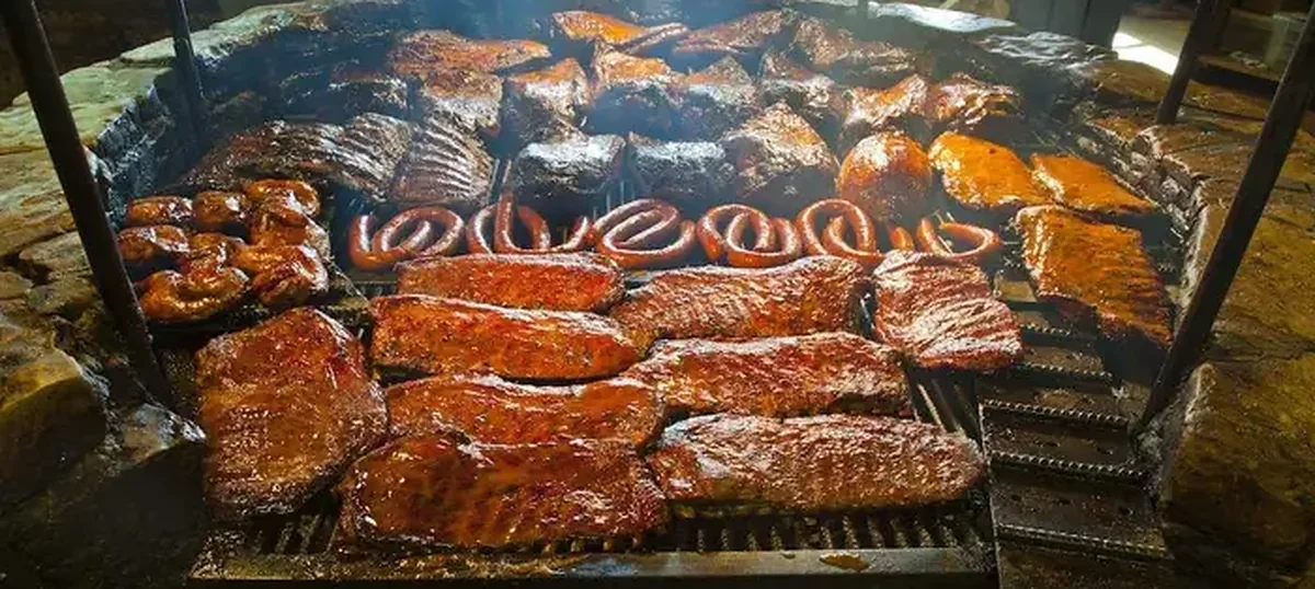 Ribs and brisket laid out across the pit at Salt Lick BBQ