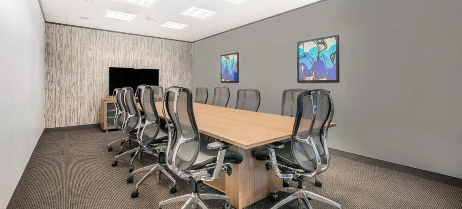 An empty office meeting room with a conference table and chairs