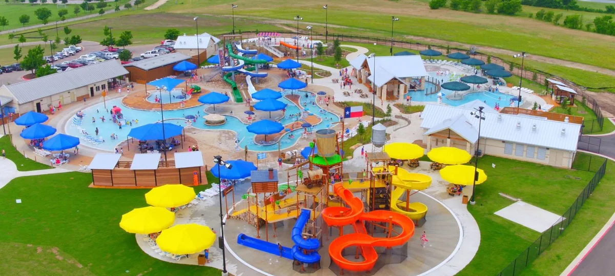 Aerial view of Rock’N River water park in Round Rock, showing the pools, shade umbrellas and slides