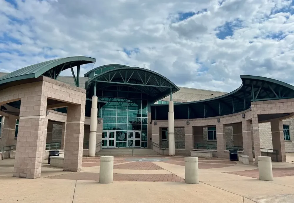 The entrance plaza of a Round Rock Independent School District campus, with curved roofs on limestone piers